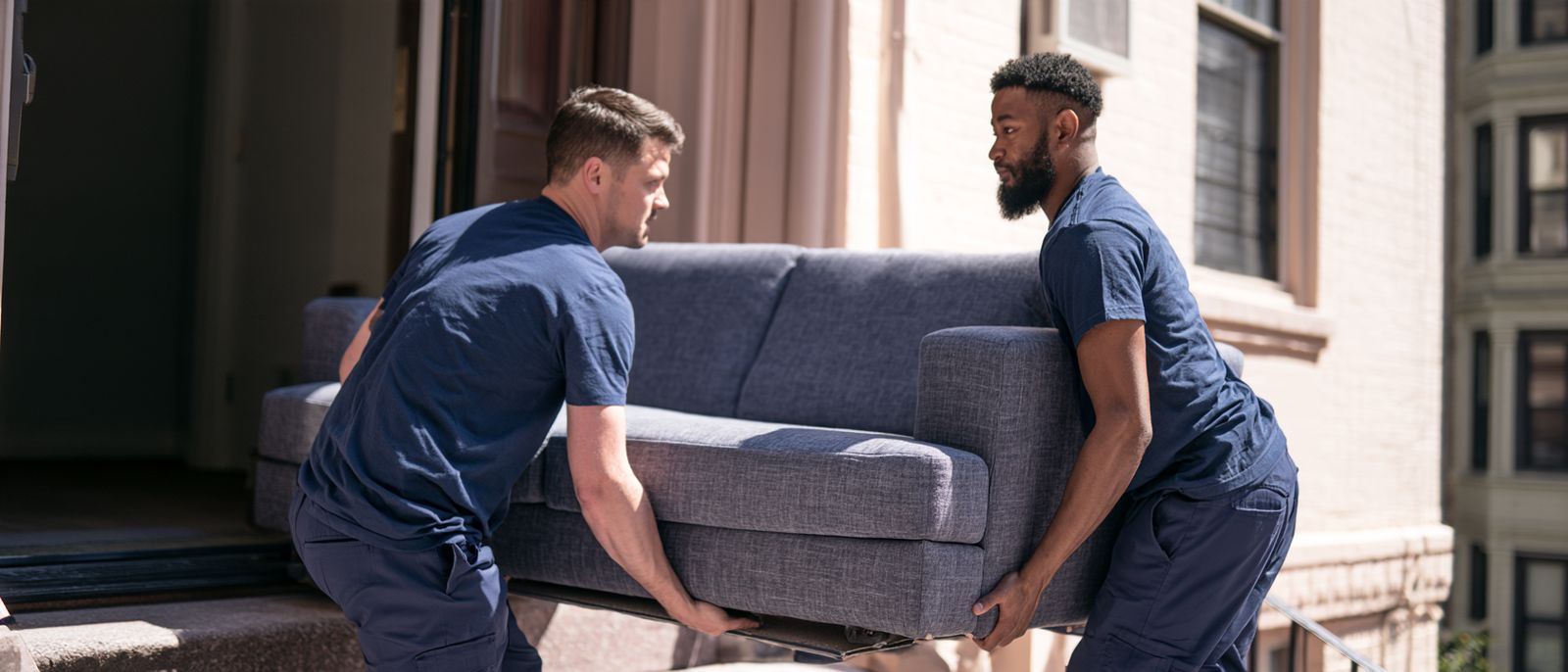 Duke Summers Moving crew lifting a sofa into a moving truck.